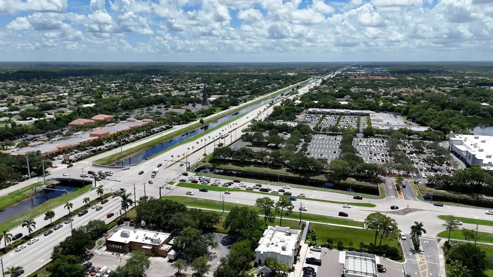 Aerial view of a busy multi-lane road and canal in Southwest Florida