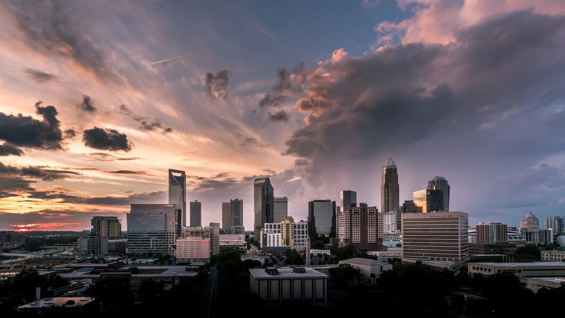 Charlotte skyline under a dramatic sunset sky