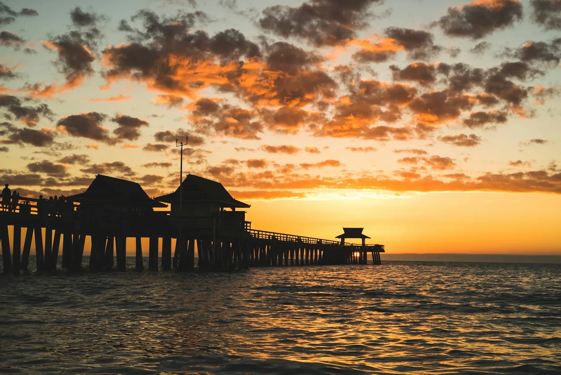 The Naples Pier silhouetted against a golden Gulf sunset