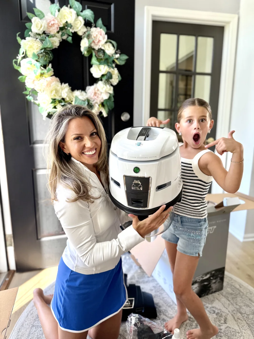 Nicole unboxing a HYLA air purifier with an excited helper