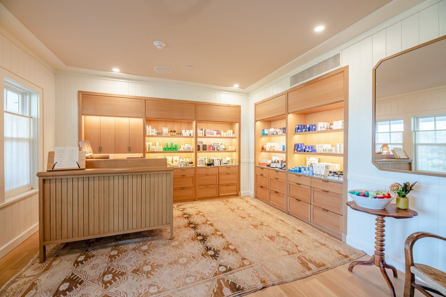 Retail shop with custom white oak display cabinetry and a fluted reception desk