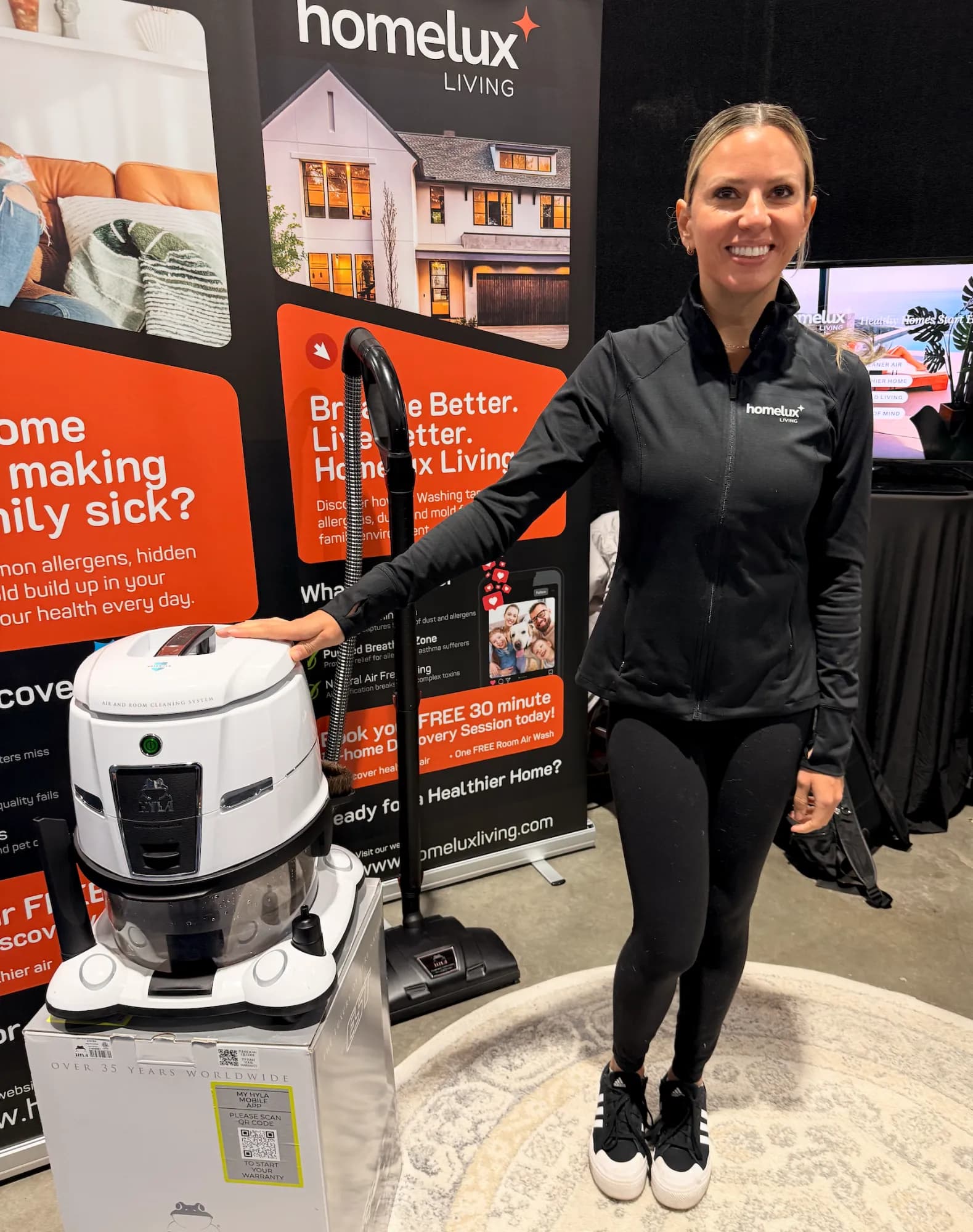 Homelux Living trade show booth with banners and a HYLA air cleaning system