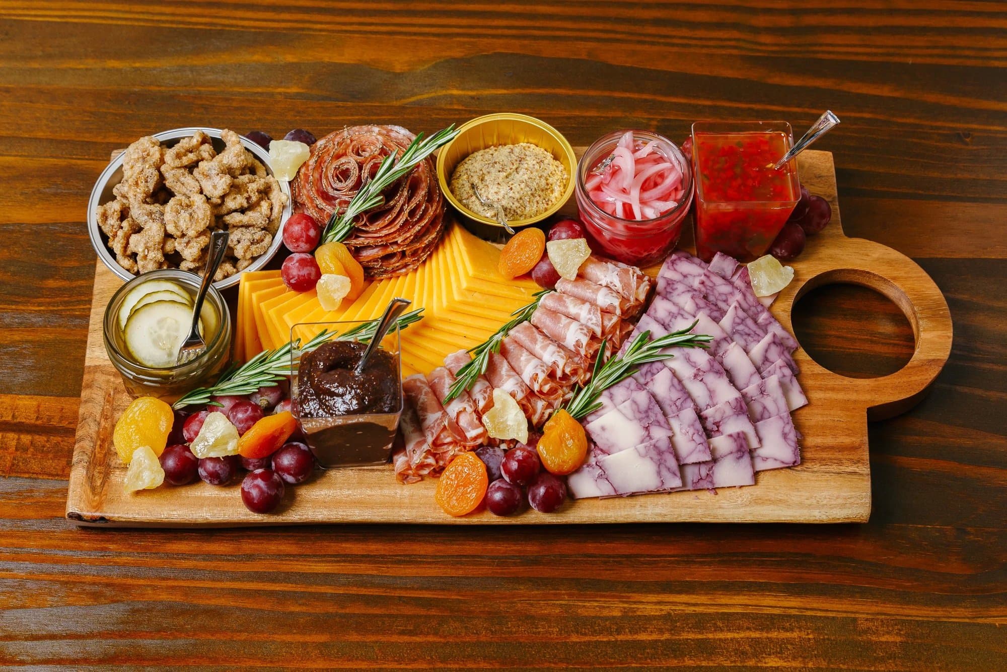 The Potbelly board with meats, cheeses, pickles and dips on a wooden board