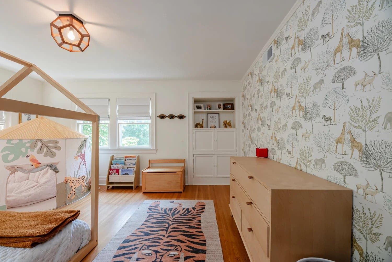 Child's room with a house-frame bed and botanical wallpaper