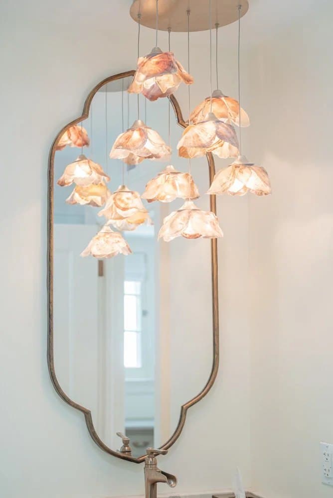 Statement pendant beside an arched mirror