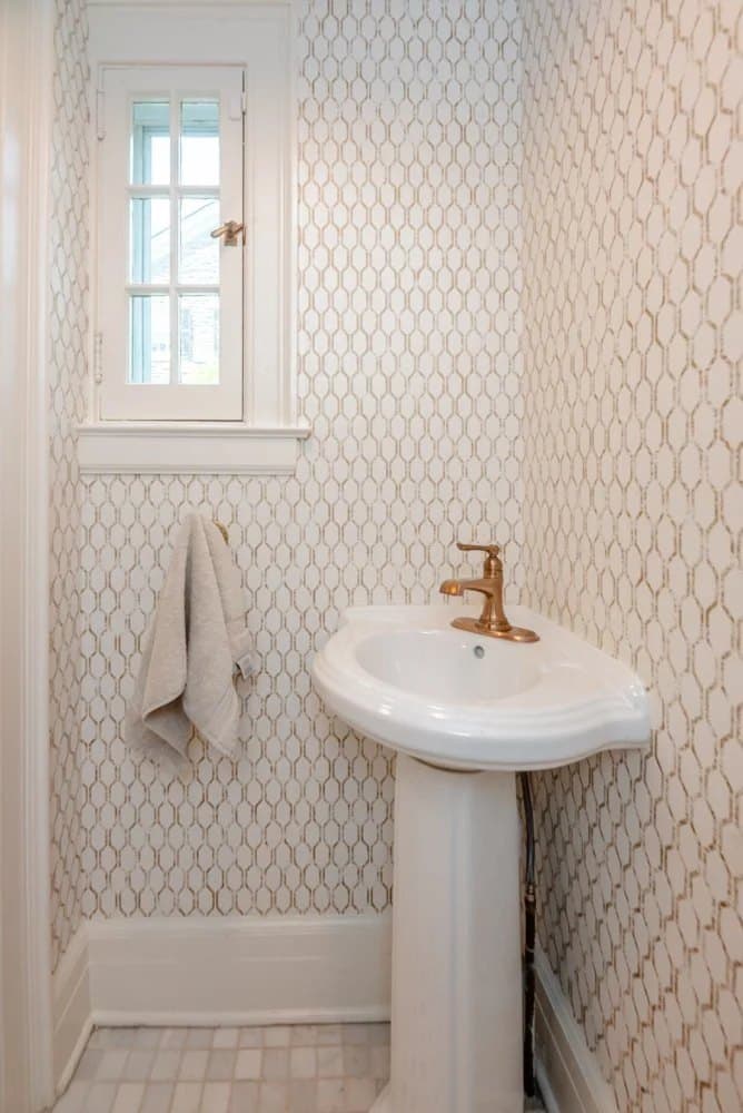 Powder room with patterned tile and a pedestal sink