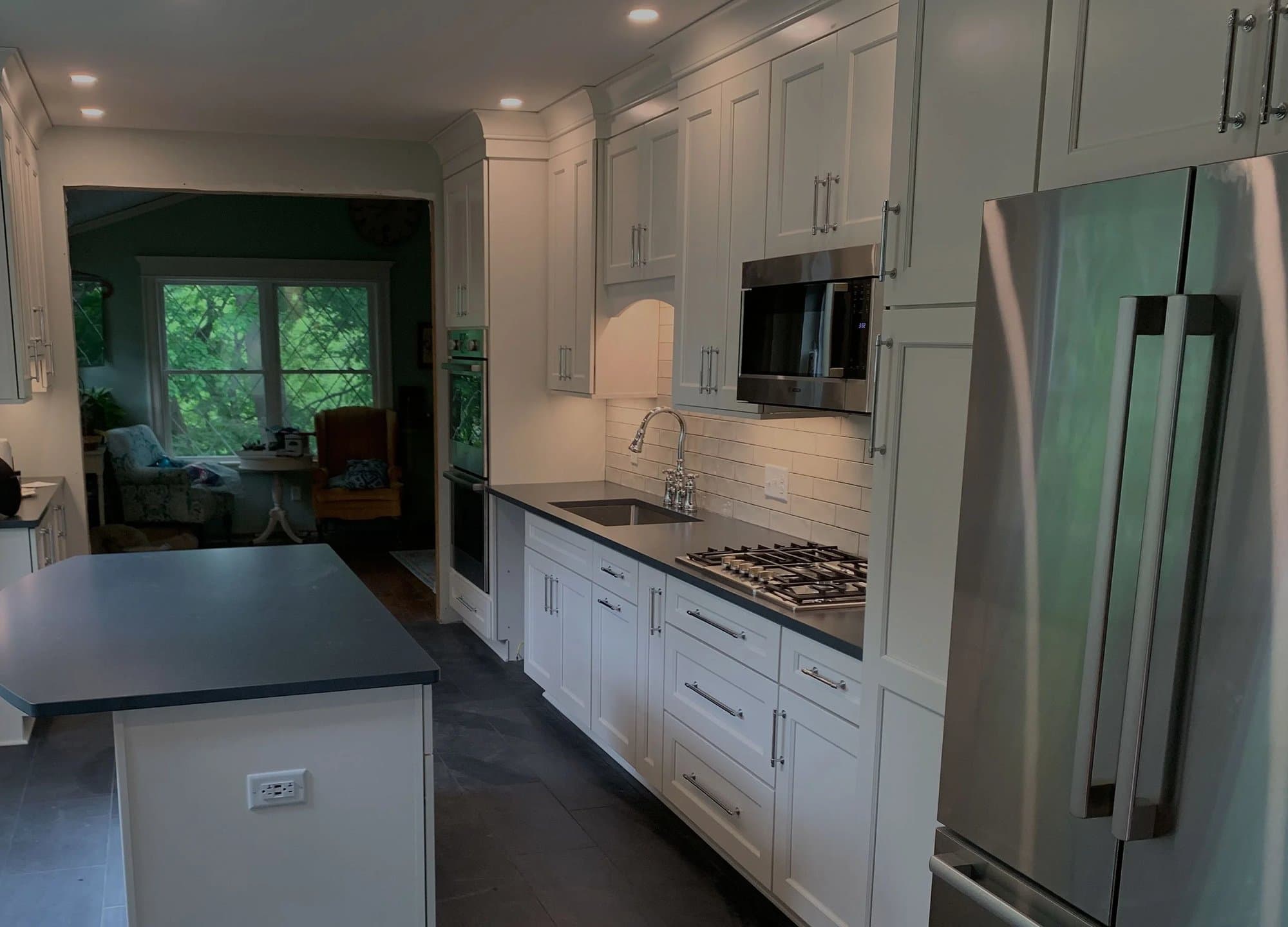 Galley kitchen with dark counters and stainless appliances