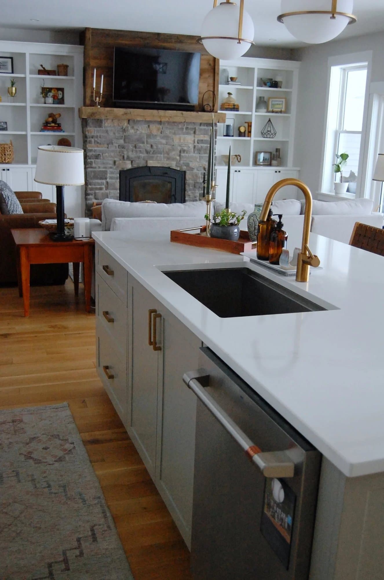 Kitchen island sink looking toward a stone fireplace