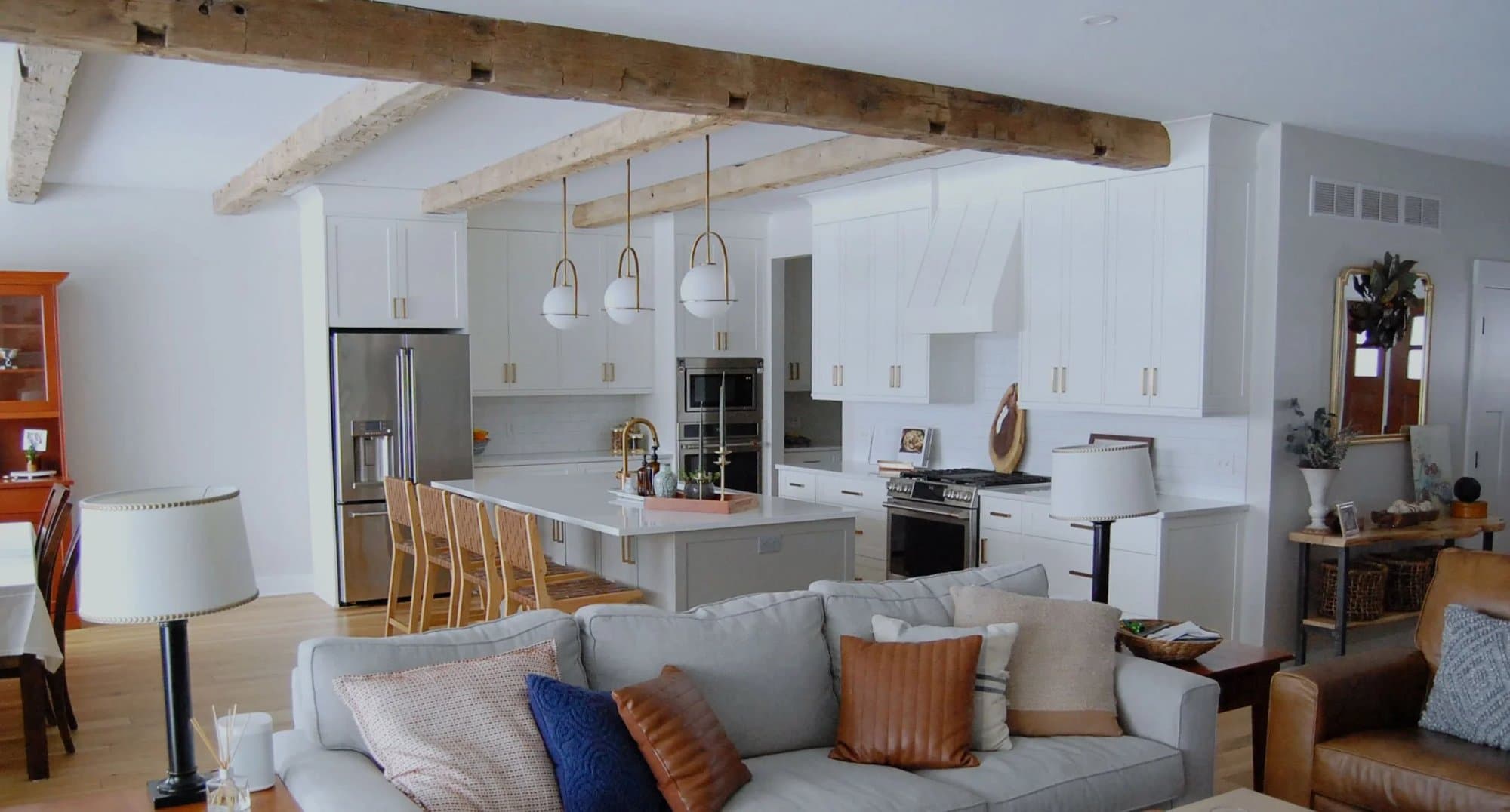 Open-plan living room and kitchen under reclaimed beams