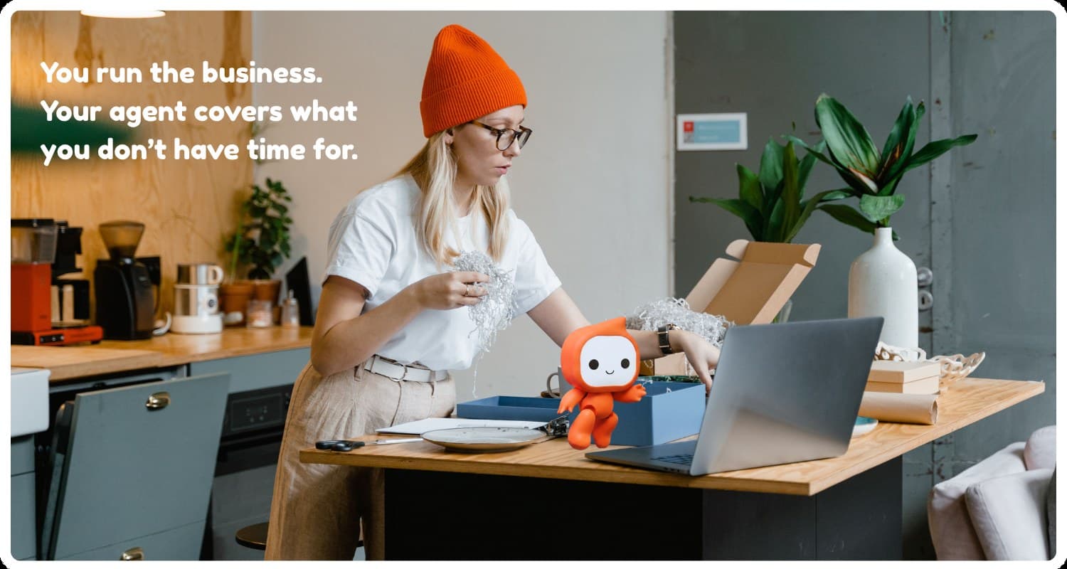 Small business owner packing orders while Noden's mascot Toby helps at the laptop